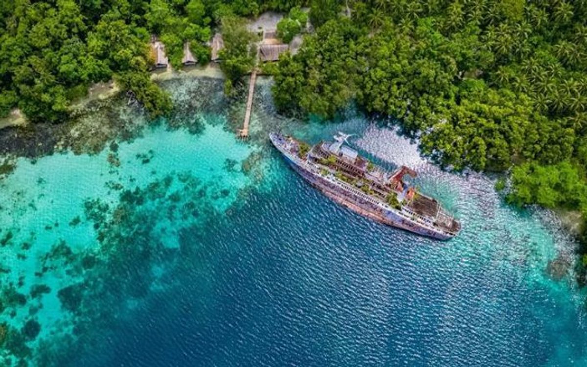 Shipwreck in clear turquoise water next to a tropical beach and lush forests in the Solomon Islands. Shipwreck in clear turquoise water next to a tropical beach and lush forests in the Solomon Islands. Shipwreck in clear turquoise water next to a tropical beach and lush forests in the Solomon Islands.